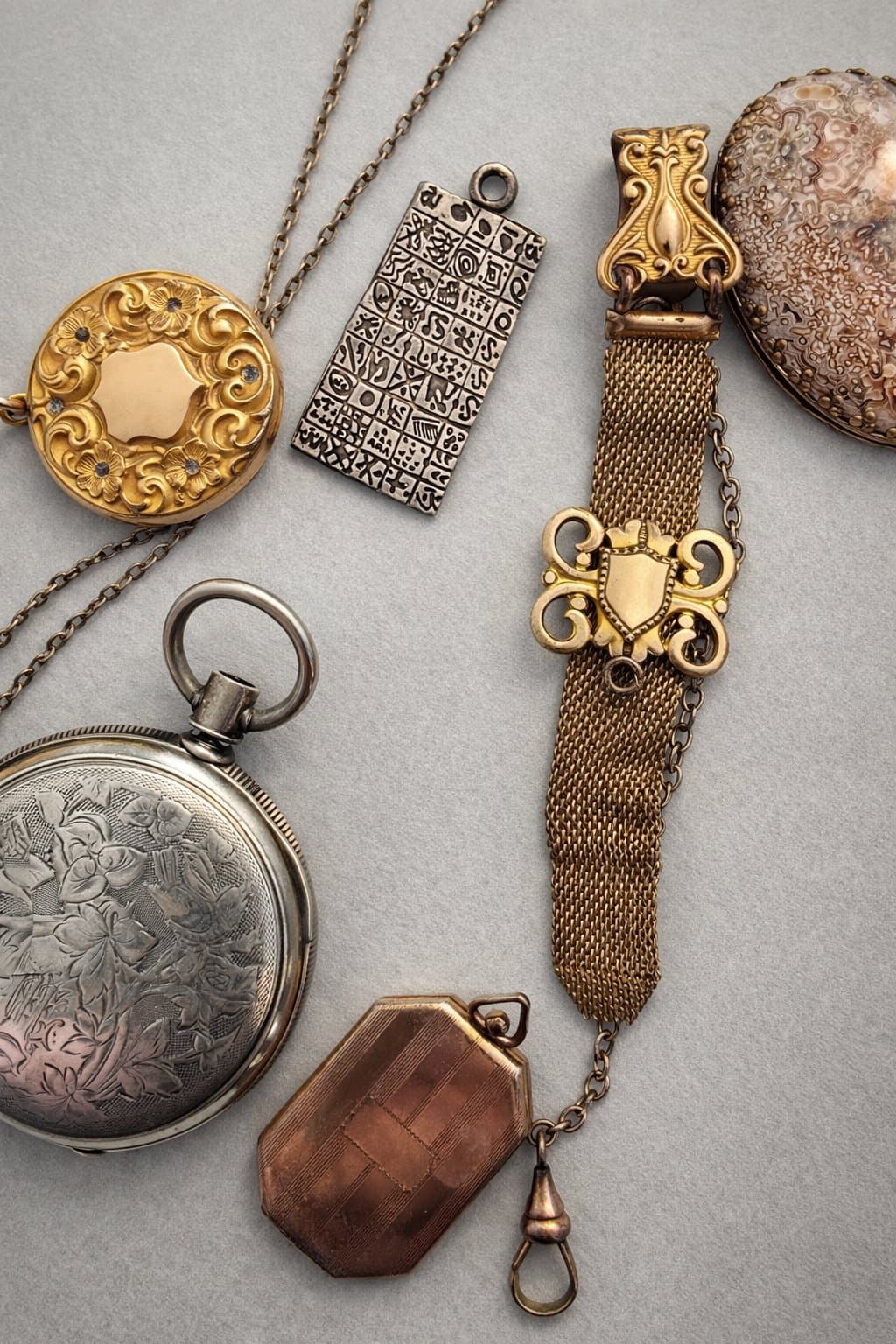 Collection of fine antique jewelry including lockets, watches, and gold pieces